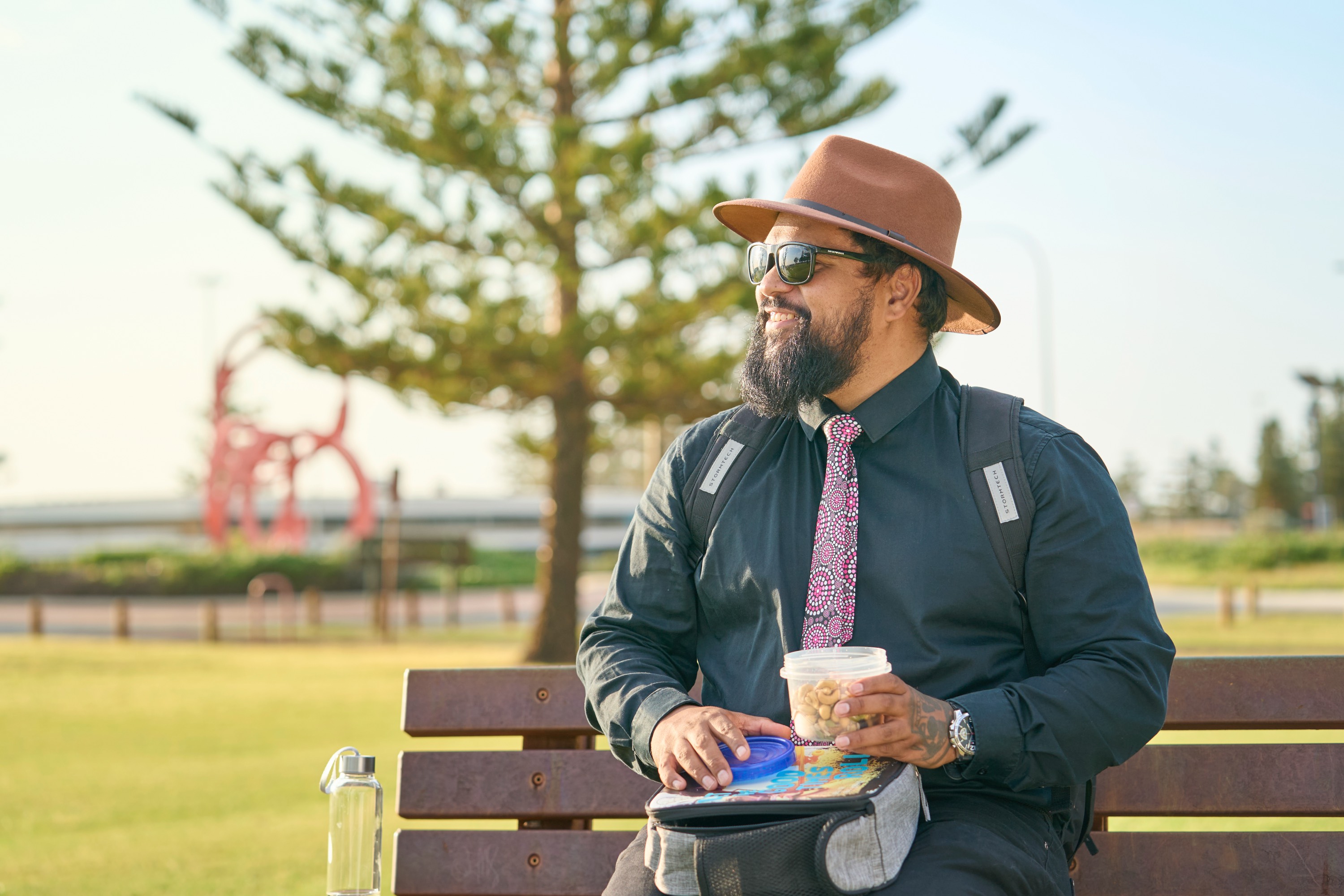Man outdoors enjoying a healthy workplace lunch in a park