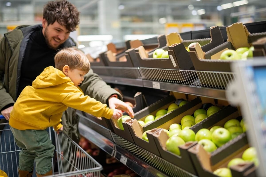 Father and son at the supermarket in the fresh produce section